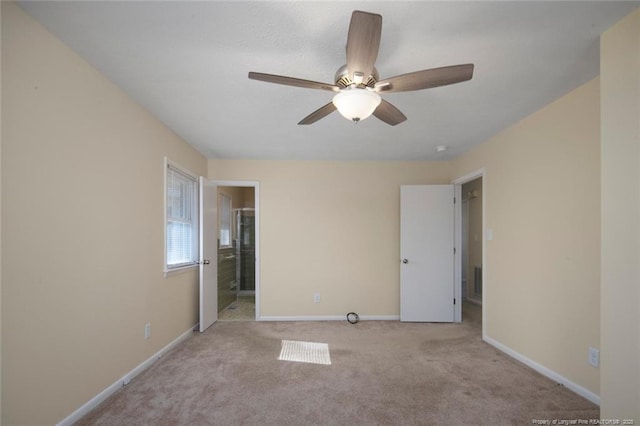 unfurnished bedroom with connected bathroom, light carpet, and ceiling fan