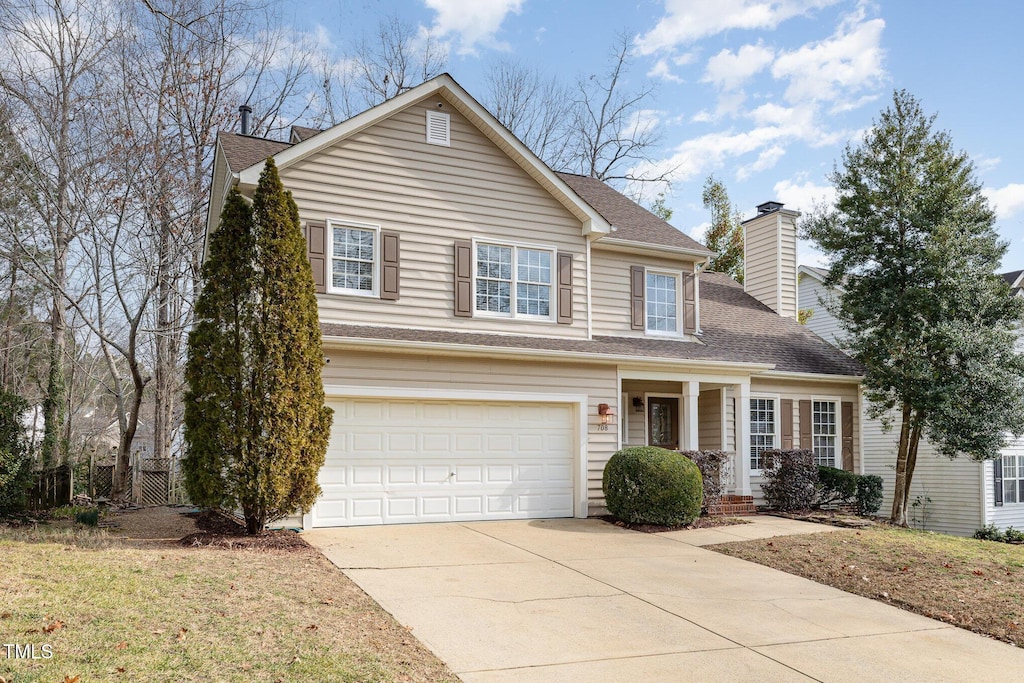 view of property with a garage and a front yard