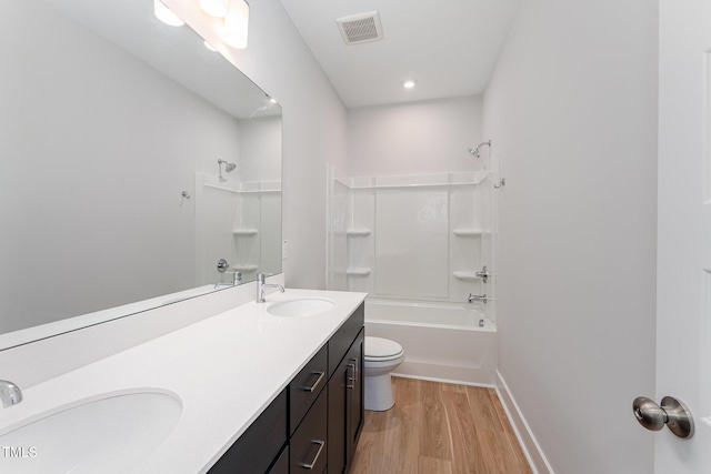 full bathroom featuring shower / washtub combination, hardwood / wood-style floors, vanity, and toilet