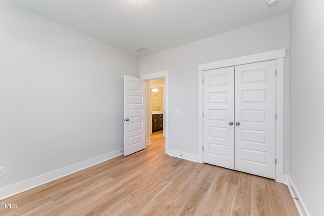 unfurnished bedroom featuring a closet and light wood-type flooring