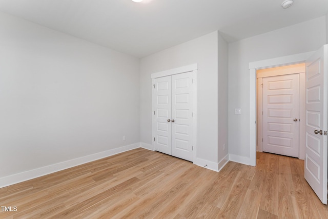 unfurnished bedroom featuring a closet and light wood-type flooring