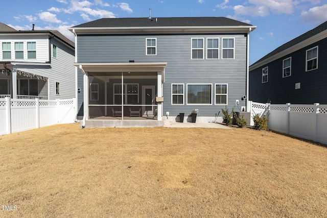 rear view of property with a yard, a patio area, and a sunroom