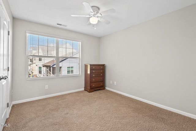 interior space with visible vents, ceiling fan, baseboards, and carpet