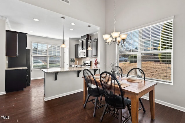 dining room featuring a chandelier, visible vents, dark wood-type flooring, and baseboards