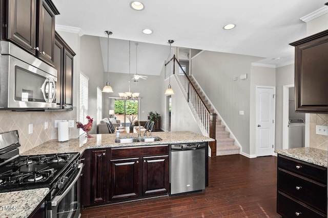 kitchen featuring a sink, stainless steel appliances, dark brown cabinetry, and a peninsula