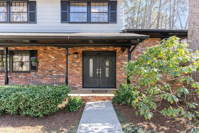 view of exterior entry with brick siding