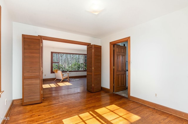 unfurnished room with light wood-style flooring and baseboards