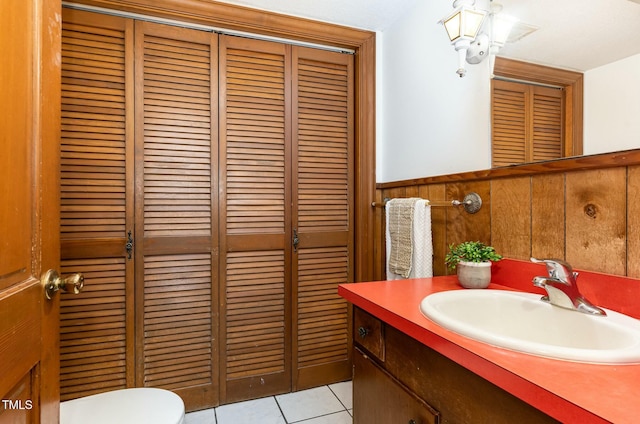 bathroom featuring tile patterned flooring, toilet, wainscoting, a closet, and vanity