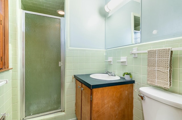 full bathroom with toilet, tile walls, a stall shower, and vanity