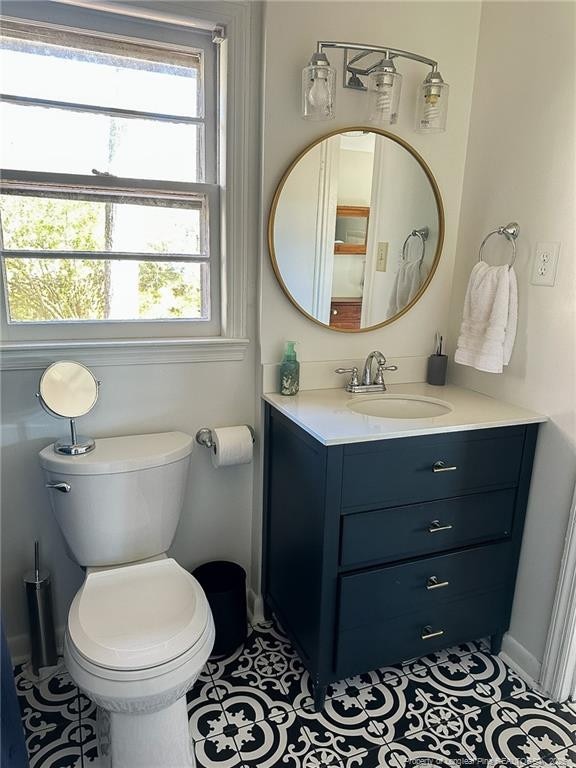 bathroom with tile patterned flooring, vanity, and toilet