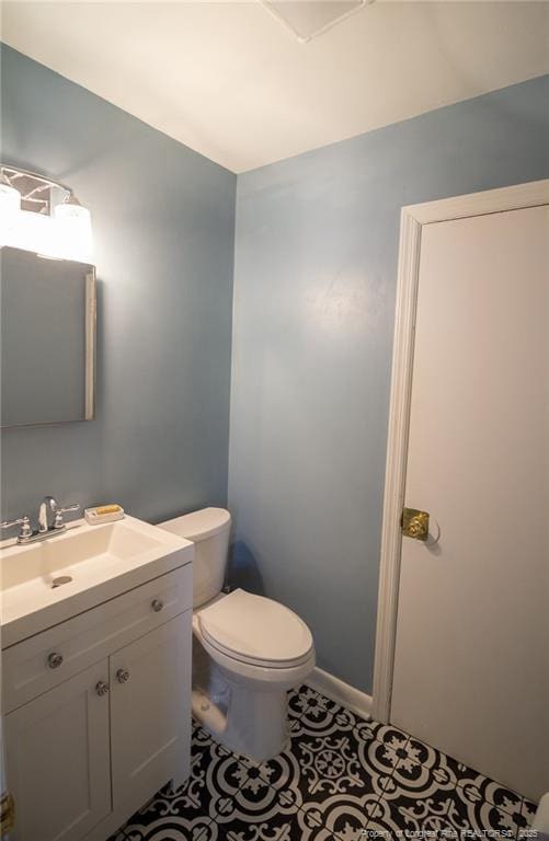 bathroom featuring vanity, toilet, and tile patterned flooring