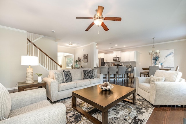 living room featuring crown molding, dark hardwood / wood-style floors, and ceiling fan with notable chandelier