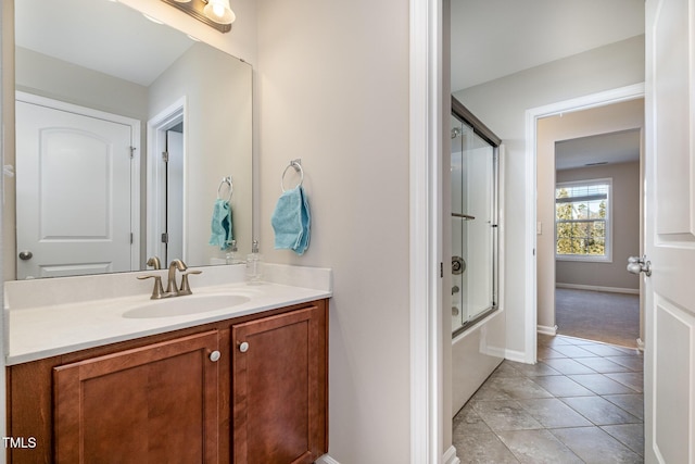 bathroom with tile patterned floors, vanity, and shower / bath combination with glass door