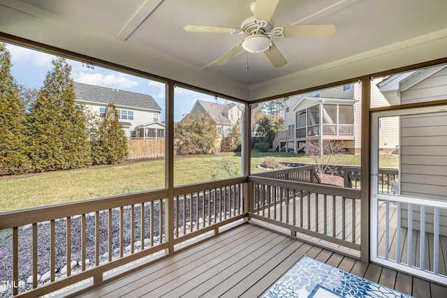 deck featuring a sunroom, a yard, and ceiling fan