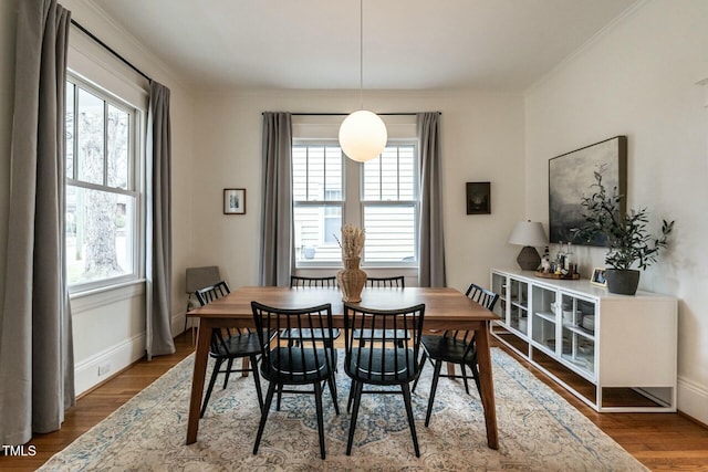 dining room with wood-type flooring and ornamental molding