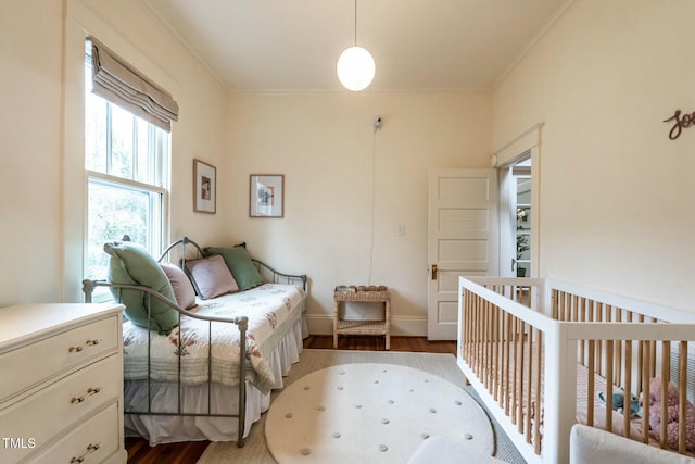 bedroom featuring crown molding and dark hardwood / wood-style flooring