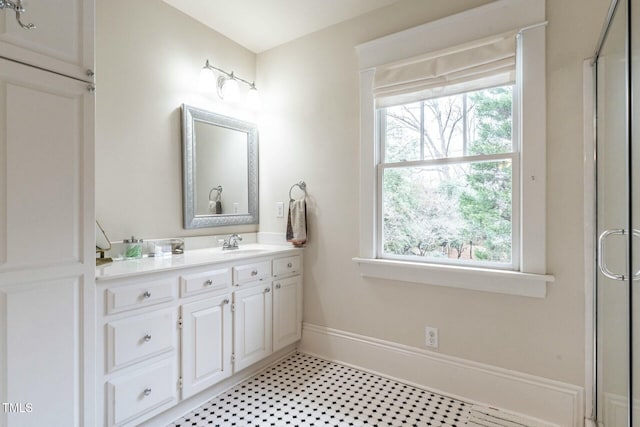 bathroom with a shower with door, vanity, and a wealth of natural light