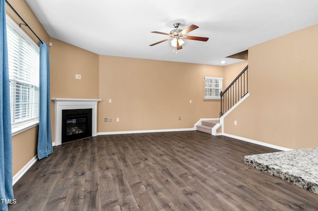 unfurnished living room with dark hardwood / wood-style floors and ceiling fan