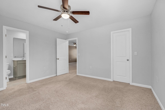 unfurnished bedroom with connected bathroom, light colored carpet, and ceiling fan