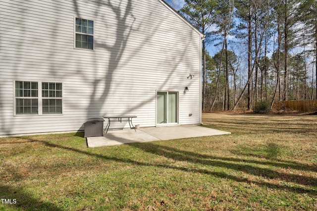 rear view of house with a lawn and a patio