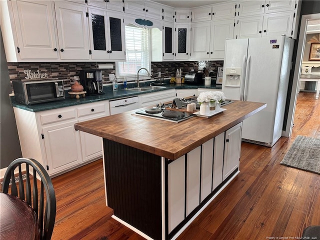 kitchen featuring a kitchen island, sink, white cabinets, and white appliances