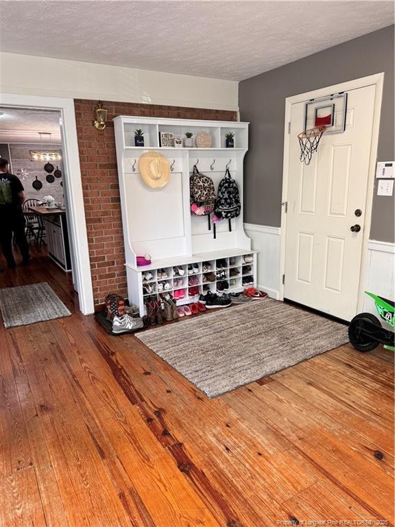 mudroom with hardwood / wood-style flooring and a textured ceiling