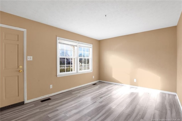 spare room with light hardwood / wood-style floors