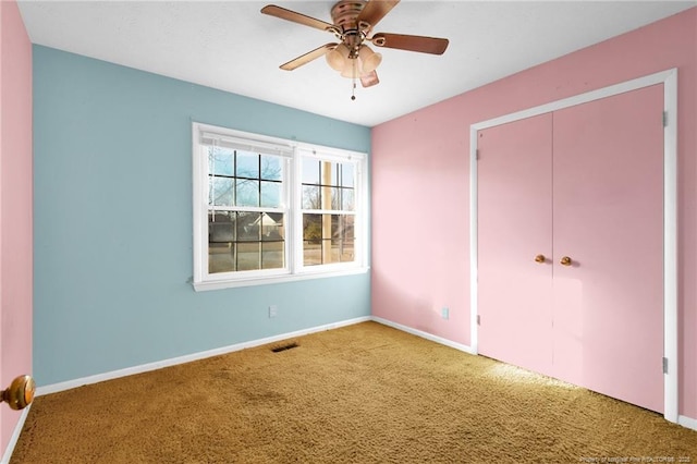 unfurnished bedroom with ceiling fan, carpet flooring, and a closet