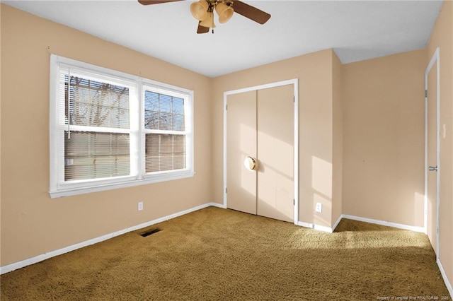 unfurnished bedroom featuring carpet floors, a closet, and ceiling fan