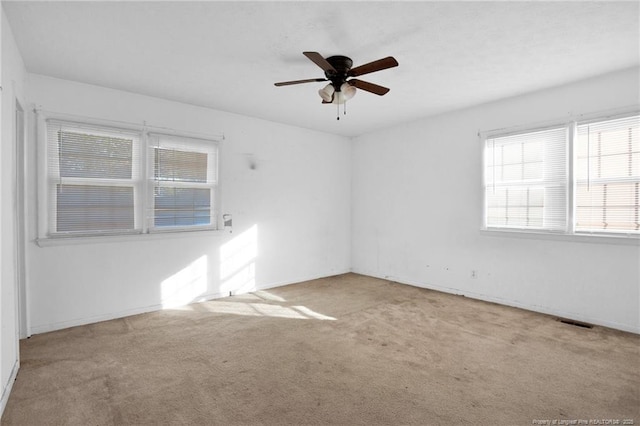 spare room with ceiling fan and light colored carpet