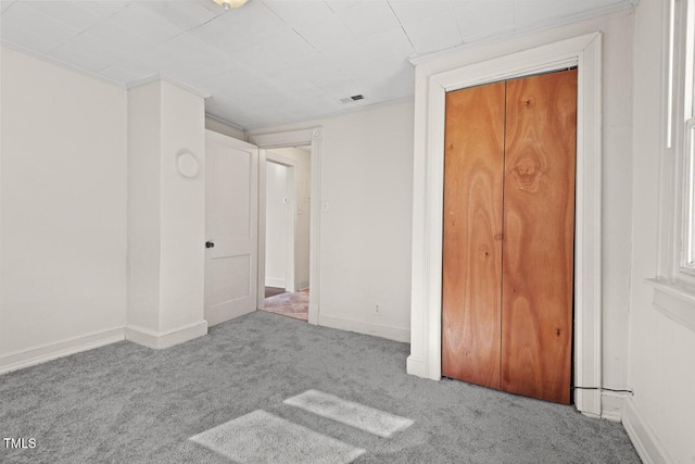 unfurnished bedroom with light colored carpet and a closet