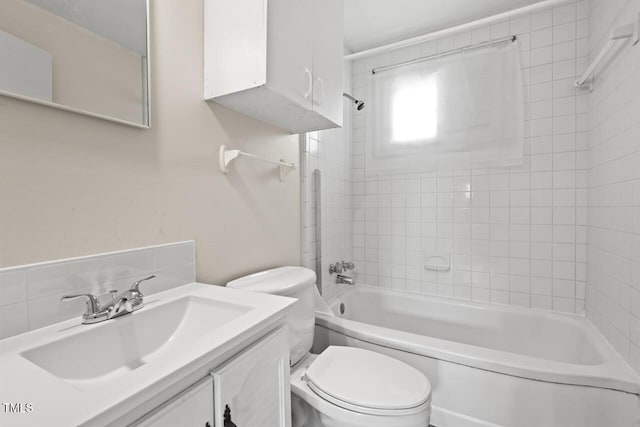 full bathroom with tiled shower / bath, vanity, and toilet