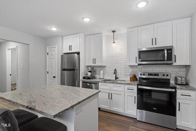 kitchen with pendant lighting, appliances with stainless steel finishes, and white cabinets