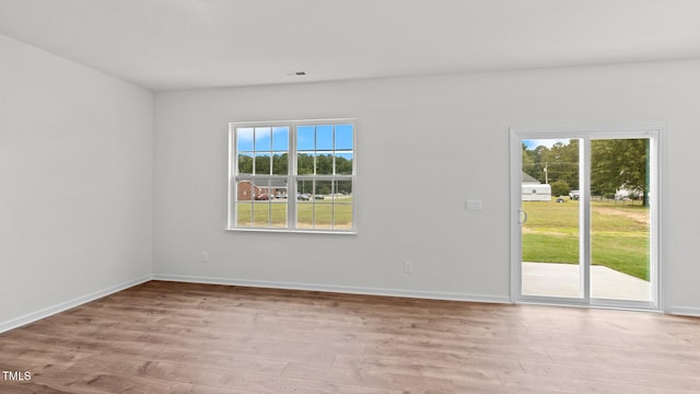 unfurnished room with light hardwood / wood-style floors and a healthy amount of sunlight