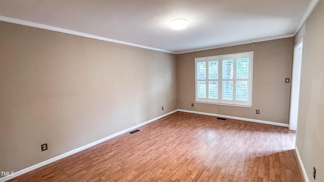 spare room featuring crown molding and light hardwood / wood-style flooring