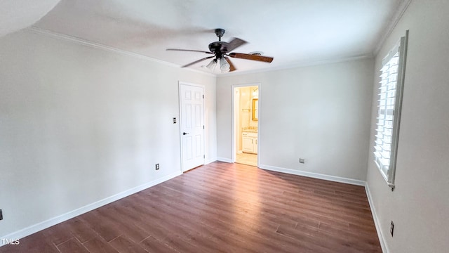 empty room featuring dark hardwood / wood-style flooring, ceiling fan, crown molding, and a healthy amount of sunlight