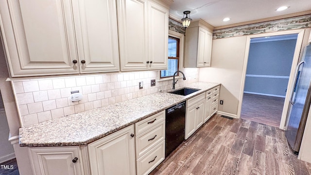 kitchen with tasteful backsplash, black dishwasher, sink, dark hardwood / wood-style flooring, and light stone countertops