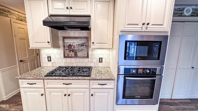 kitchen with built in microwave, black gas stovetop, white cabinets, and oven