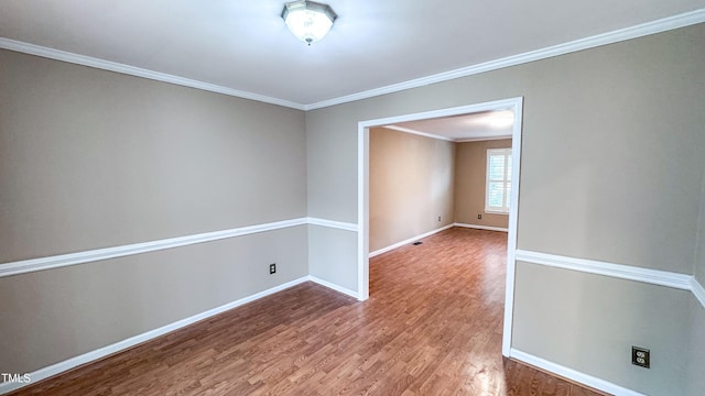 empty room with crown molding and hardwood / wood-style flooring