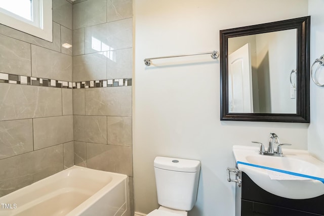 full bathroom featuring tiled shower / bath, vanity, and toilet