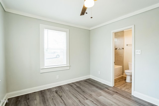 unfurnished bedroom with crown molding, ceiling fan, ensuite bath, and light hardwood / wood-style flooring