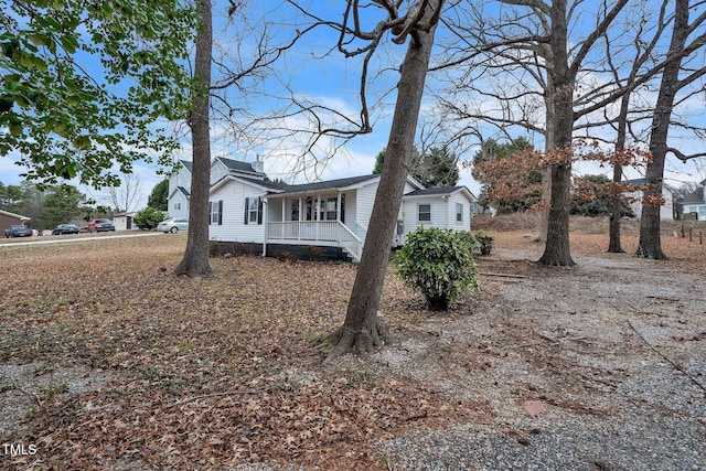 view of side of property featuring covered porch