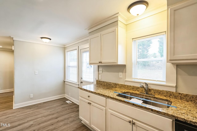 kitchen featuring stone counters, white cabinetry, and sink