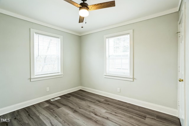 unfurnished room with crown molding, dark wood-type flooring, and ceiling fan