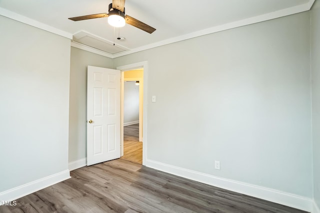 spare room featuring wood-type flooring, ornamental molding, and ceiling fan