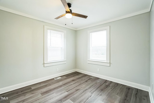 spare room featuring crown molding, wood-type flooring, and ceiling fan