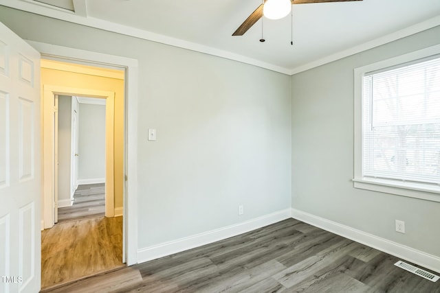 empty room featuring crown molding, hardwood / wood-style floors, and ceiling fan