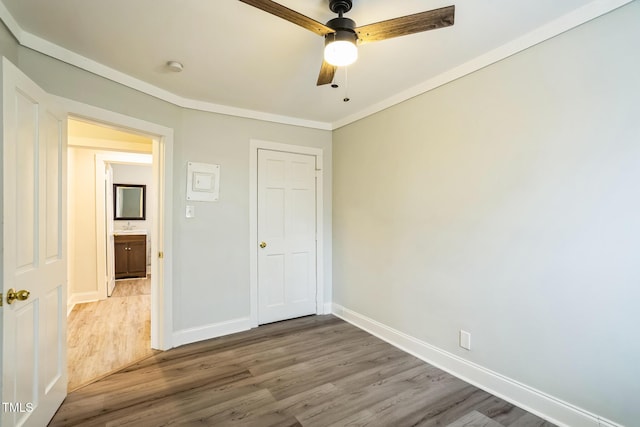 unfurnished bedroom with sink, crown molding, wood-type flooring, and ceiling fan