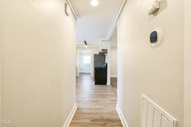 corridor featuring ornamental molding and light wood-type flooring