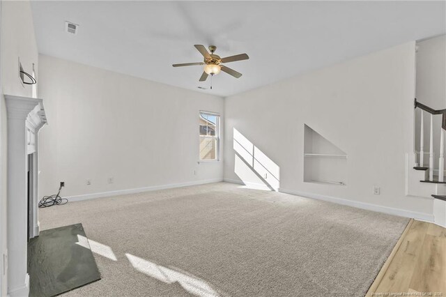 living room featuring ceiling fan, light colored carpet, and built in features